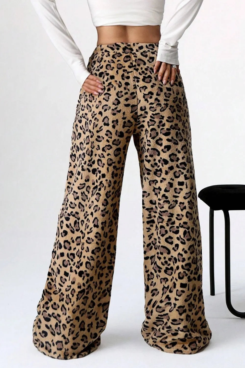 Leopard print pants worn by a person on a white background