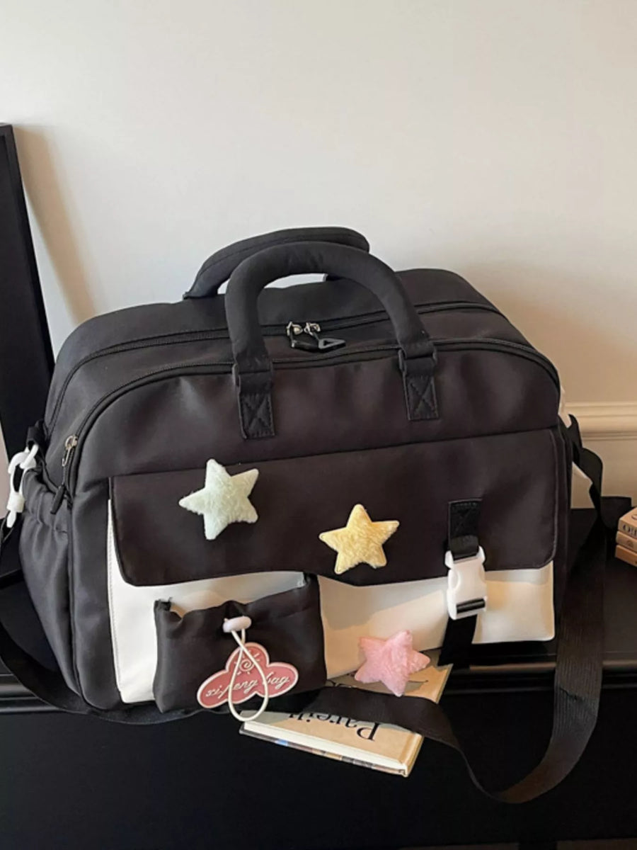 Black travel bag with star decorations on a black surface