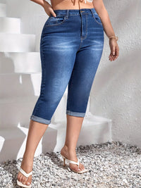Person wearing blue denim capri pants against a white background