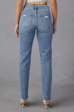 Person wearing blue jeans on a gray background