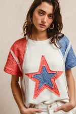 Woman wearing a white t-shirt with a red and blue star design on a beige background