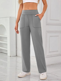 Person wearing gray high-waisted pants in a minimalistic setting