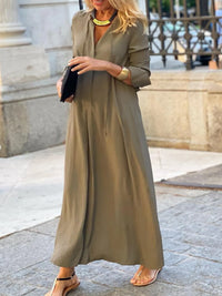 Woman wearing a long olive green dress in an urban setting