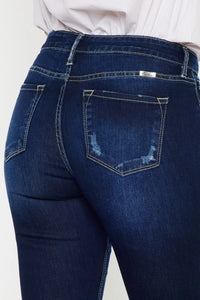 Blue jeans with a white shirt underneath on a light gray background