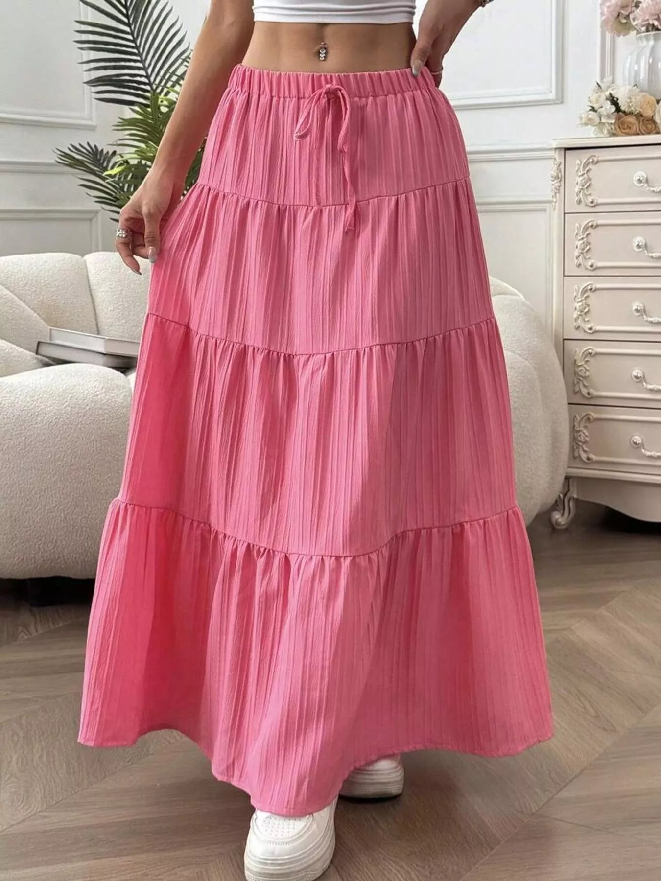Person wearing a pink tiered skirt in a room with furniture and decor.
