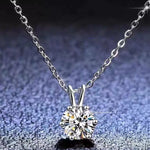 Silver necklace with a diamond pendant on a textured gray background