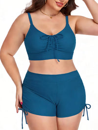 Woman wearing a blue two-piece swimsuit with a white background