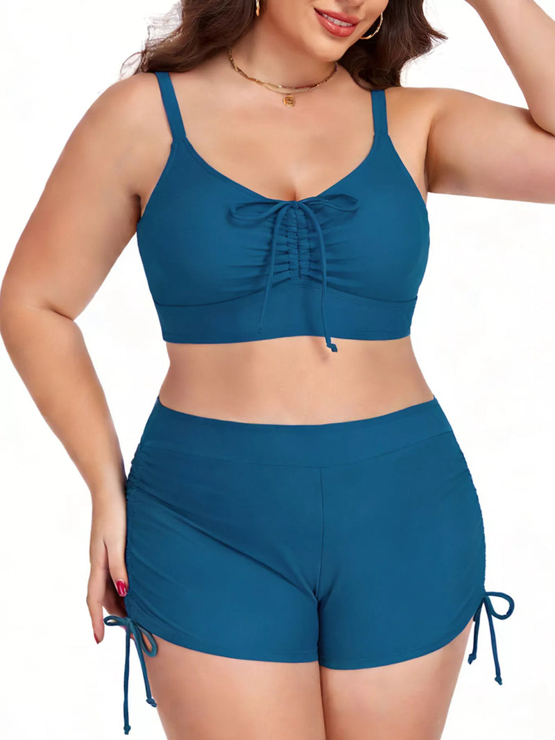 Woman wearing a blue two-piece swimsuit with a white background