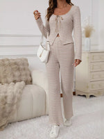 Woman in a striped outfit standing in a living room.
