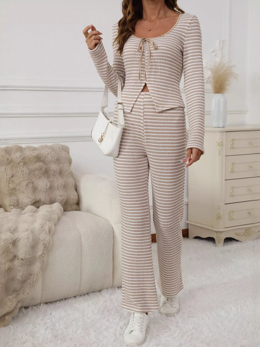 Woman in a striped outfit standing in a living room.