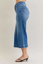 Blue jeans worn by a person on a plain background