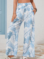 Person wearing blue and white leaf-patterned pants on a neutral background