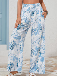 Person wearing blue and white leaf-patterned pants on a neutral background