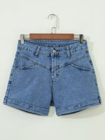 Blue denim shorts on a hanger against a white background