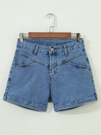 Blue denim shorts on a hanger against a white background
