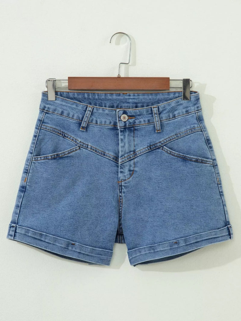 Blue denim shorts on a hanger against a white background