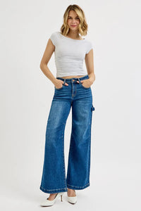 Woman wearing a white top and blue jeans on a white background