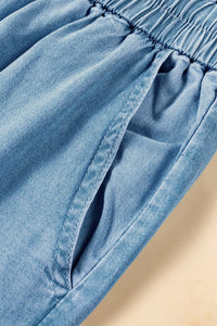 Close-up of blue denim fabric with a beige background