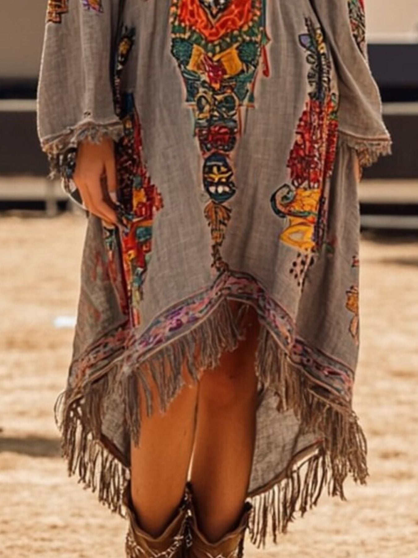 Colorful embroidered jacket with fringe details on a neutral background