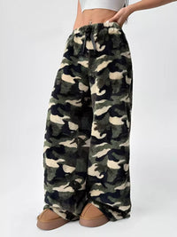 Camouflage patterned pants worn by a person on a white background