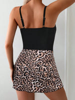 Person wearing a black top and leopard print skirt against a white background