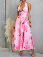 Woman wearing a pink floral dress against a gray wall.