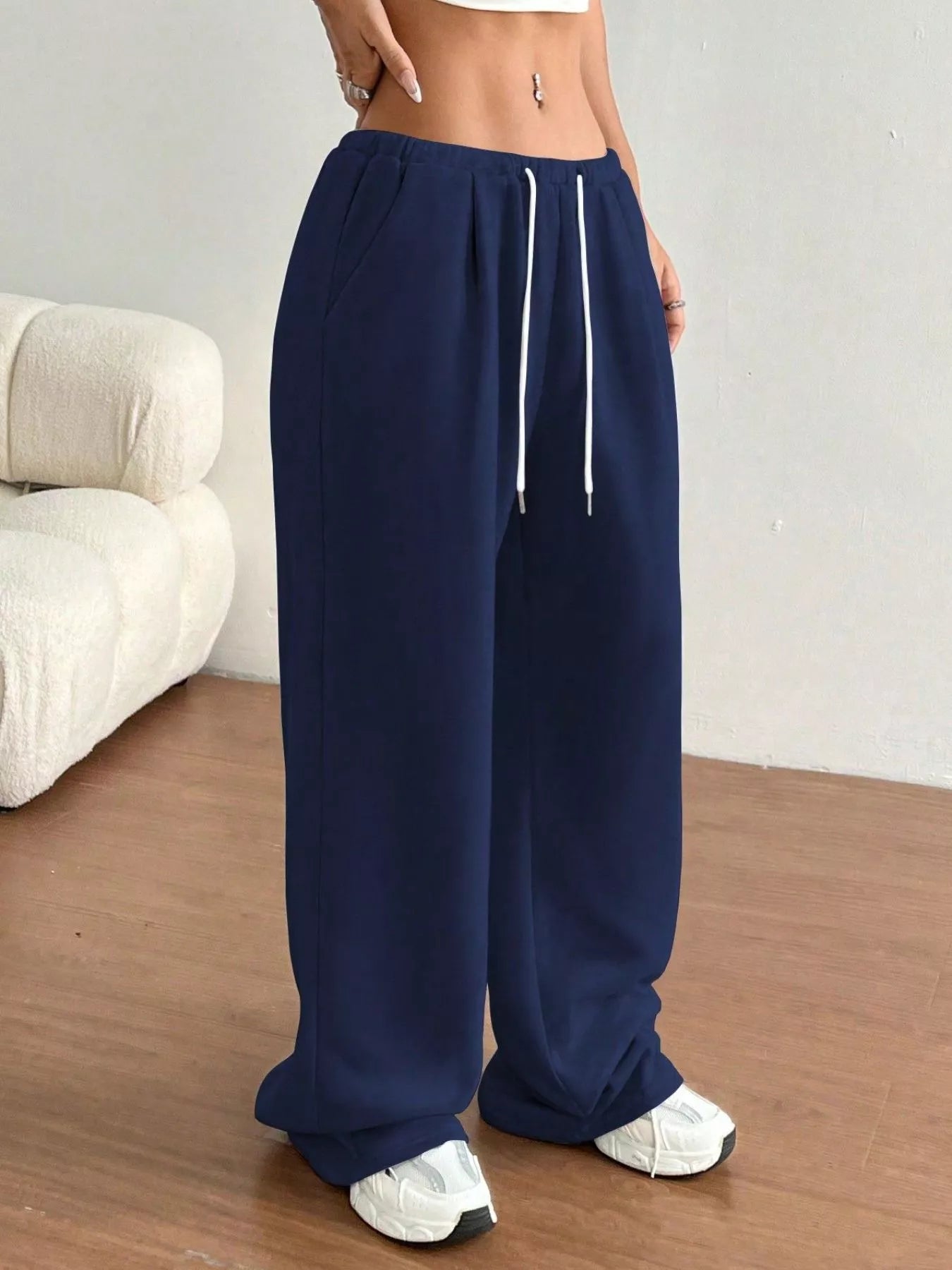 Navy blue wide-leg pants with a white drawstring worn by a person indoors.