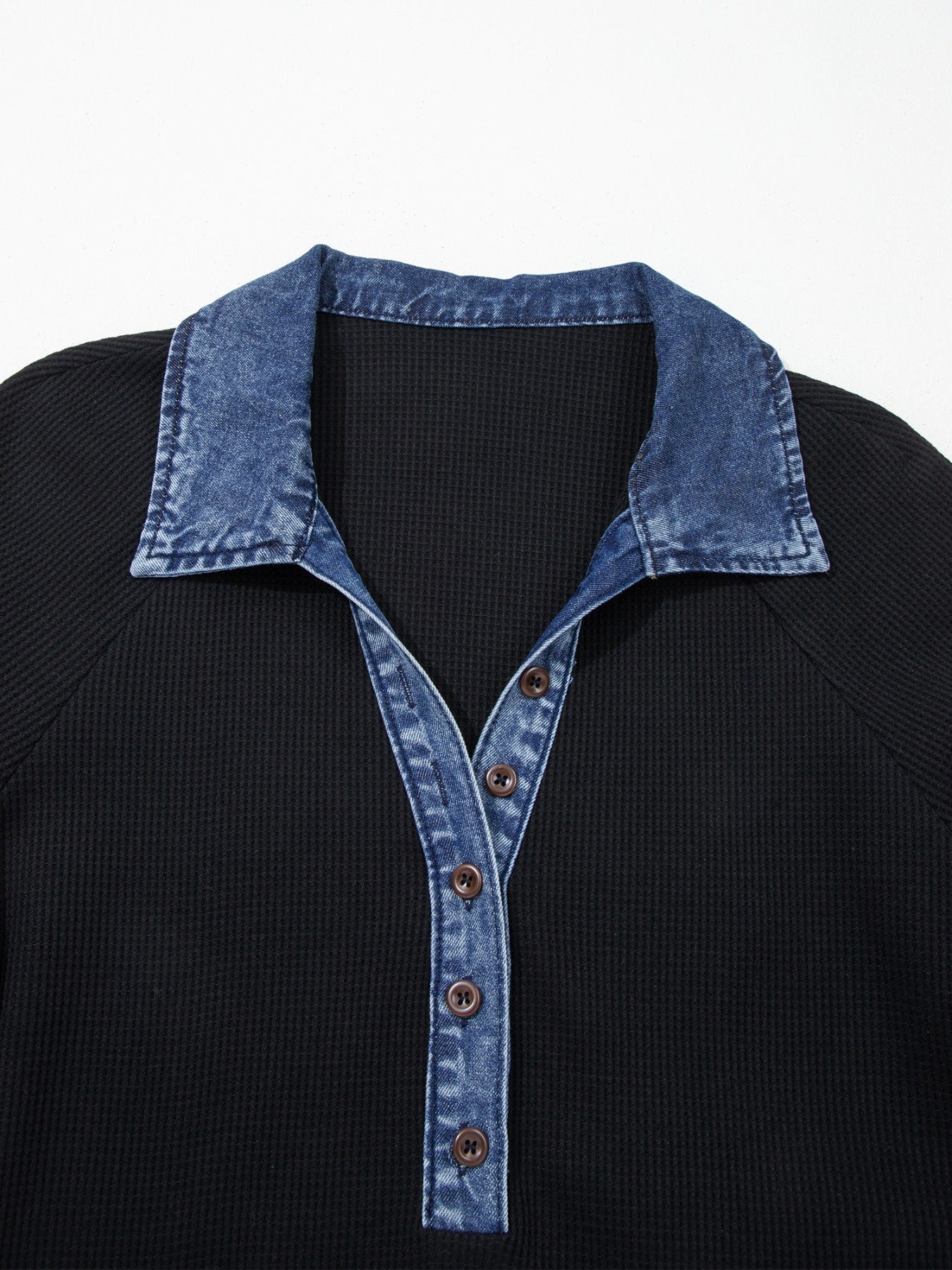 Black shirt with a denim collar and buttons on a white background