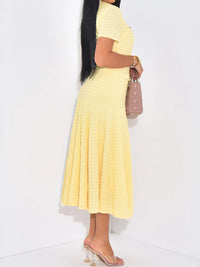 Woman wearing a yellow dress with a plain white background