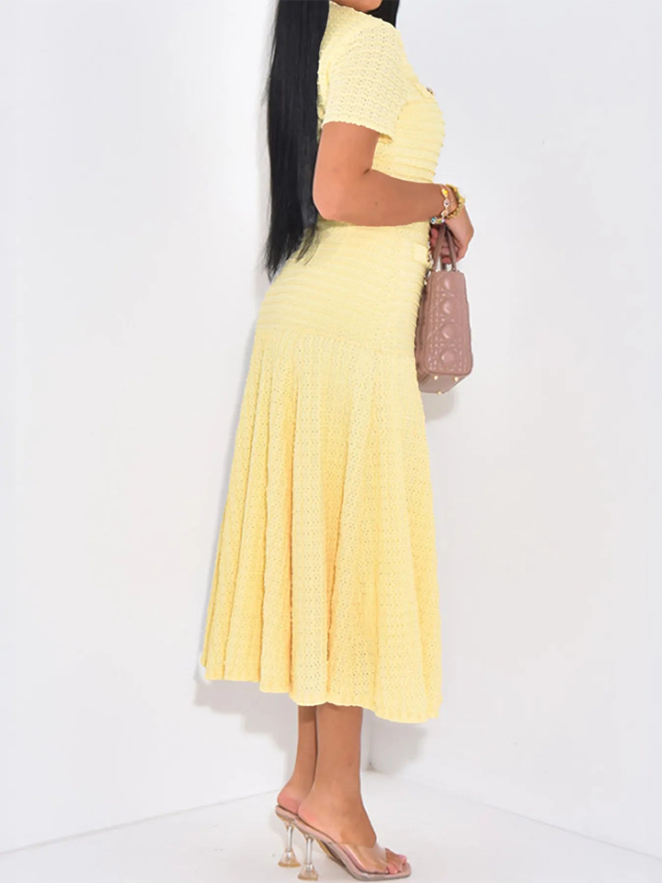 Woman wearing a yellow dress with a plain white background