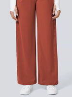 Brown wide-leg pants worn with a white top and white sneakers on a light gray background