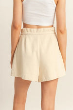 Beige skirt worn by a person on a plain background