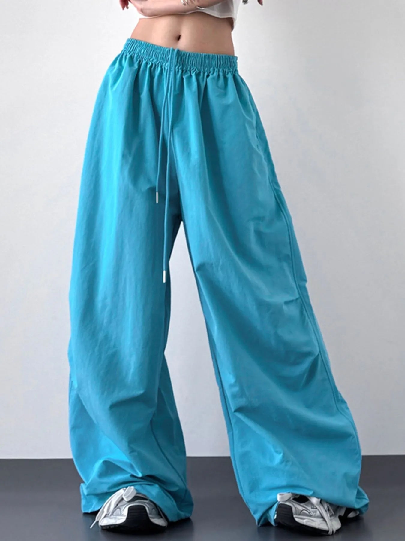 Turquoise wide-leg pants worn by a person on a plain background