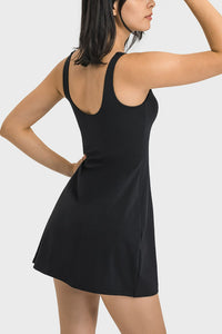 Woman wearing a black sleeveless dress against a white background