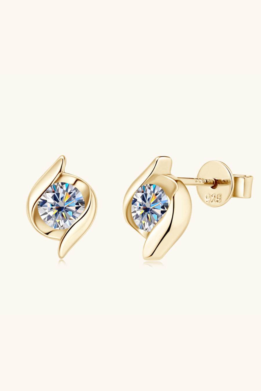 Gold earrings with clear gemstones on a white background