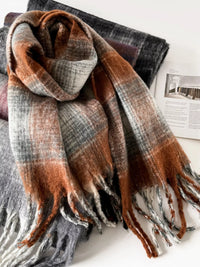 Plaid scarf with brown, gray, and red colors on a white surface.