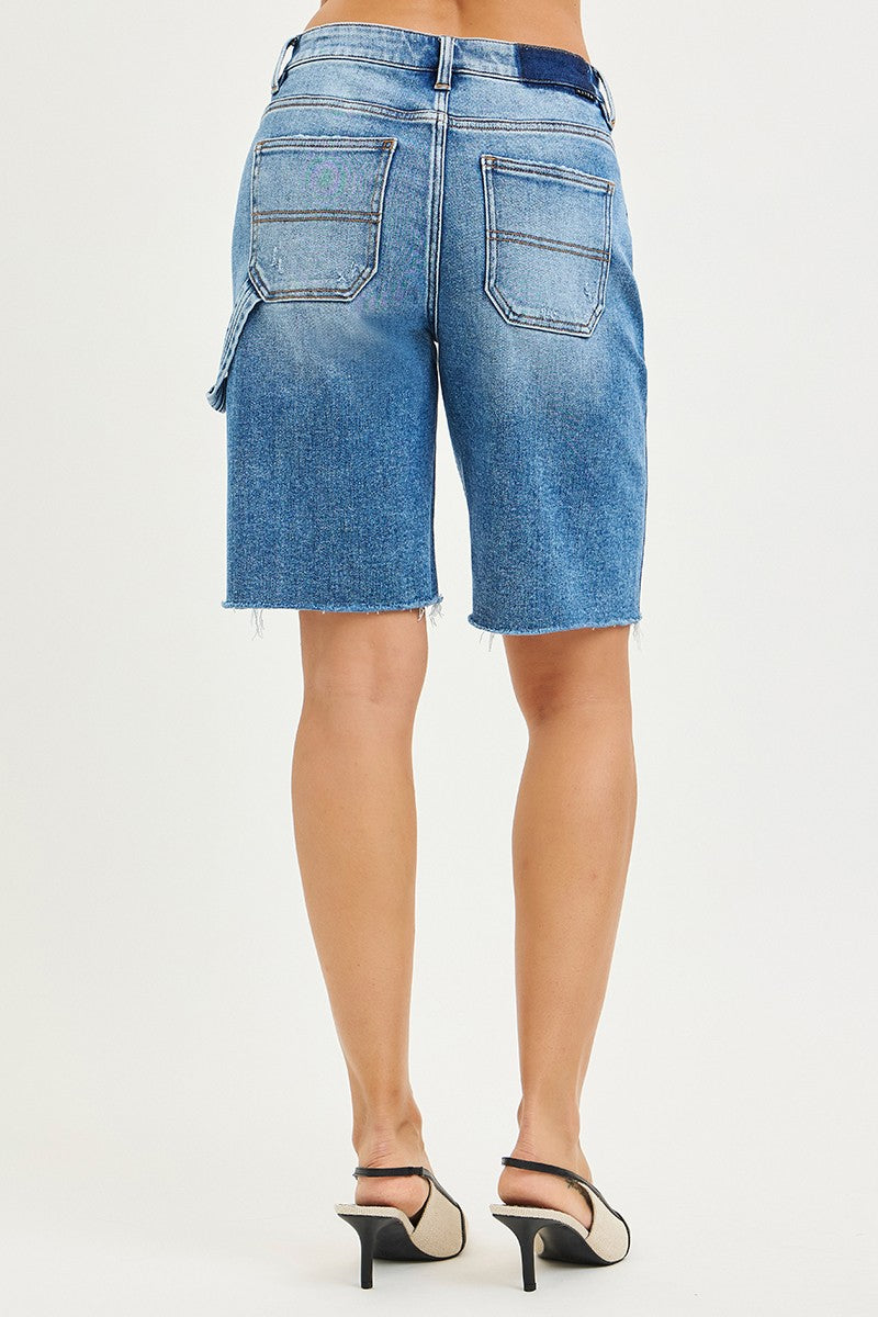 Blue denim shorts worn by a person on a white background