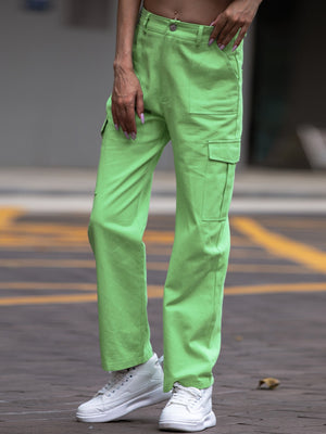 Person wearing bright green pants and white sneakers on a blurred background