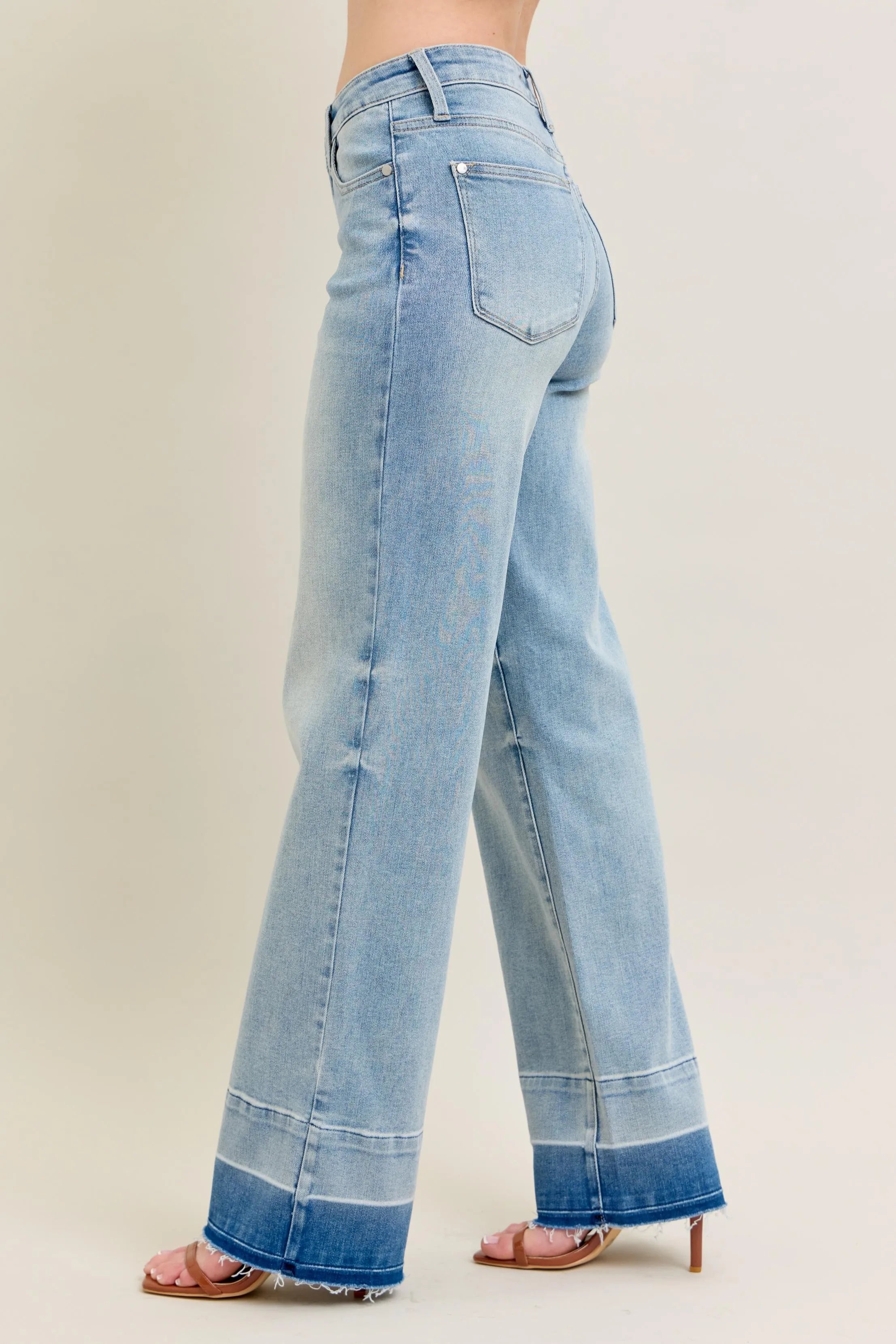 Light blue jeans worn by a person on a beige background