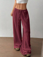 Person wearing maroon wide-leg pants against a plain background