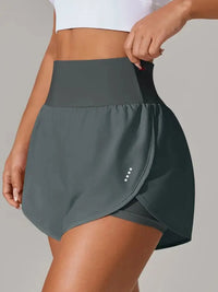 Person wearing a gray athletic skirt on a plain background