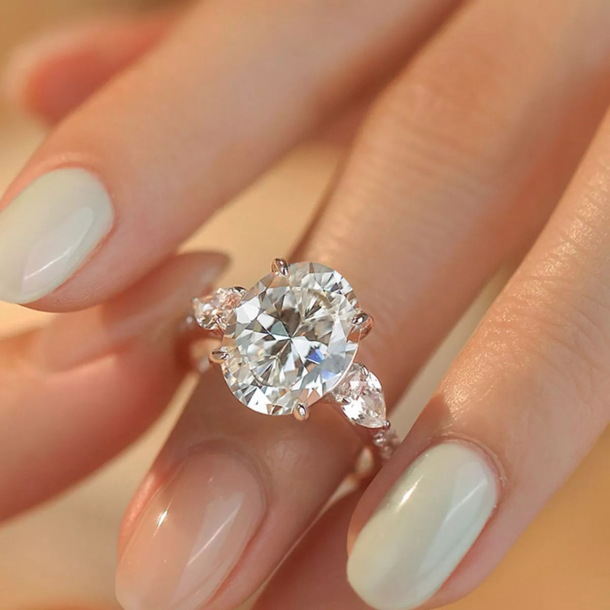 Diamond ring on a hand with light nail polish