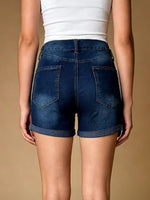 Person wearing blue denim shorts on a beige background