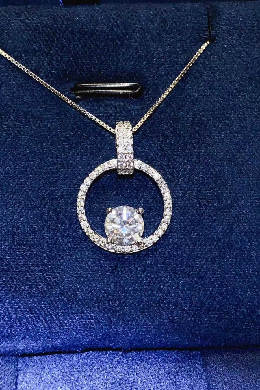 Diamond pendant necklace on a blue fabric background