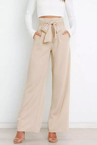 Beige wide-leg pants with a tie waist worn by a person against a white background