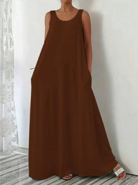 Brown sleeveless dress worn by a person against a white wall.