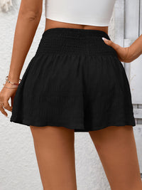 Black shorts worn by a person against a light background