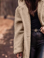 Person wearing a beige coat with a blurred natural background