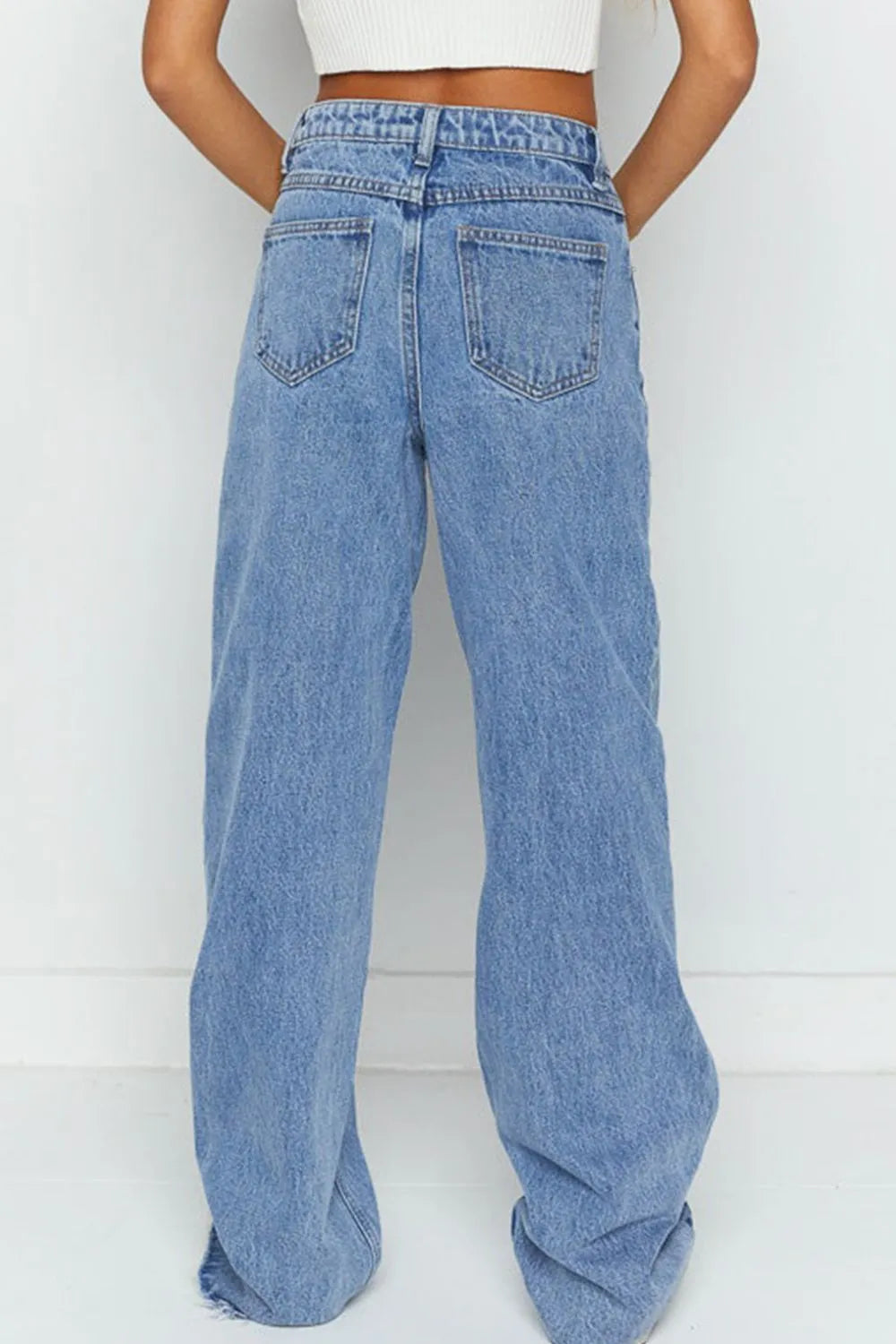 Blue jeans worn by a person on a white background