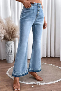 Light blue flared jeans worn by a person indoors with decorative elements.